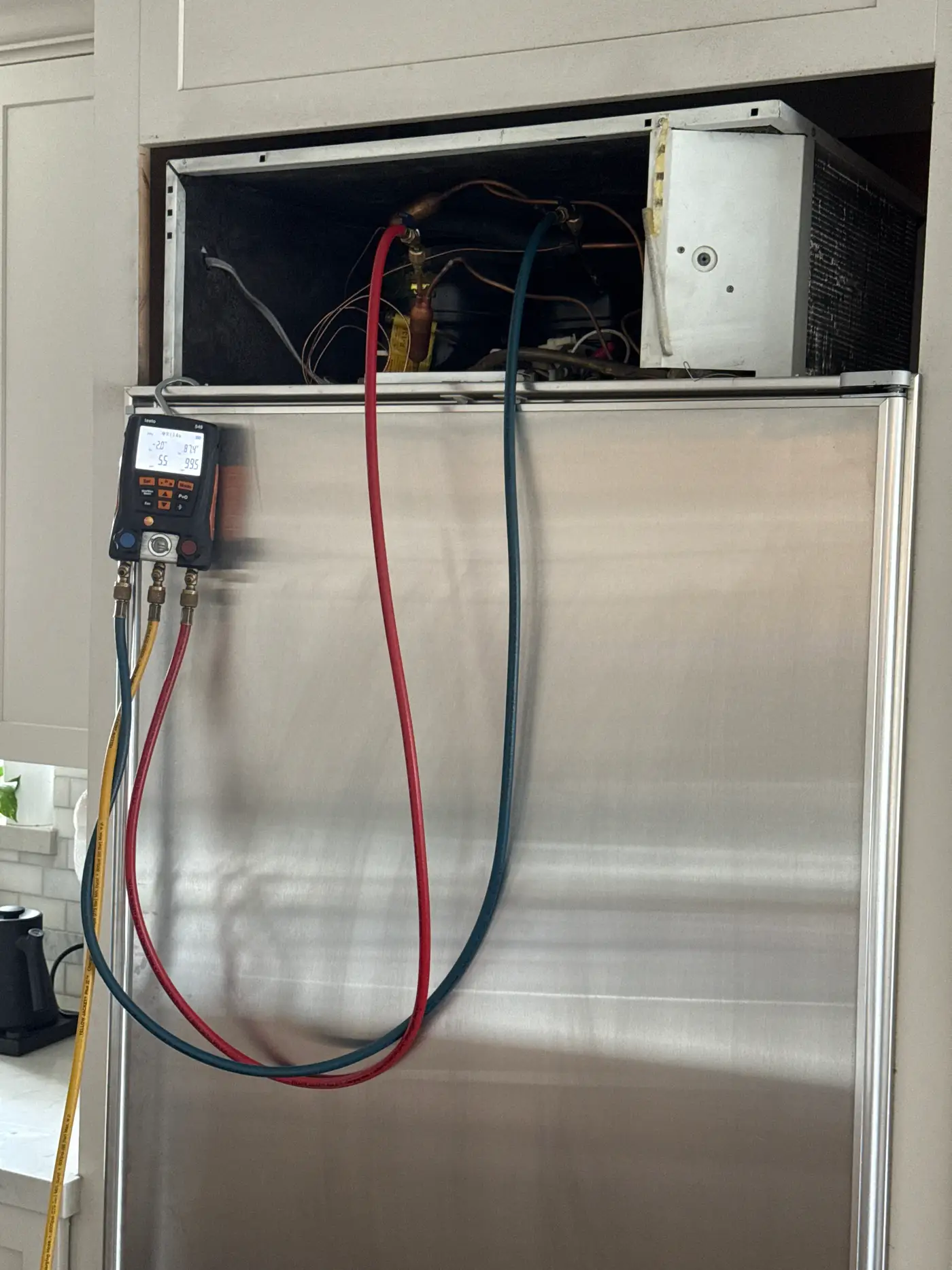 Digital manifold gauges connected to a Sub-Zero built-in refrigerator during refrigerant charging and pressure testing in Redondo Beach