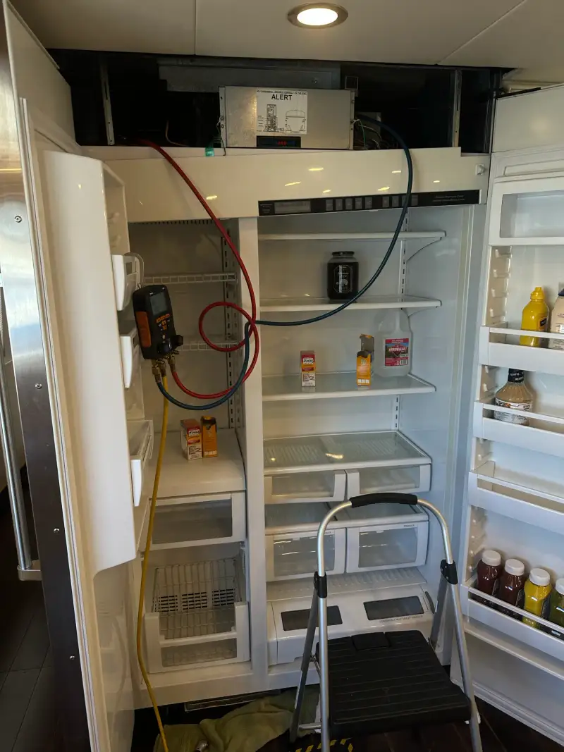Digital manifold gauge connected to a built-in refrigerator during sealed-system diagnostics