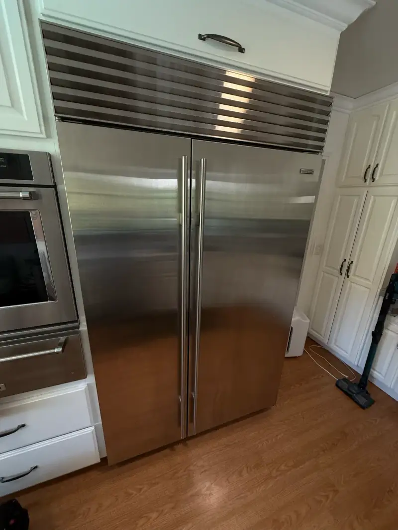 Sub-Zero built-in side-by-side refrigerator in stainless steel with its signature louvered grille