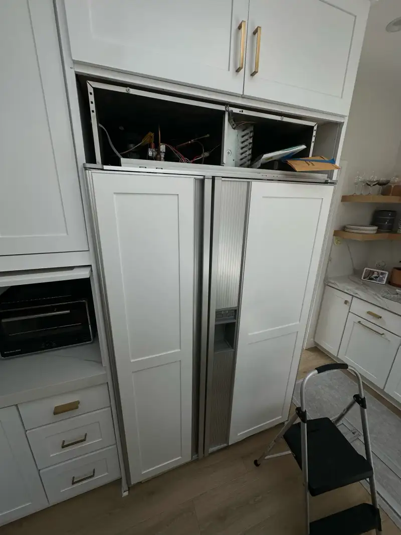Panel-ready Sub-Zero built-in side-by-side refrigerator with white panels during a sealed-system repair