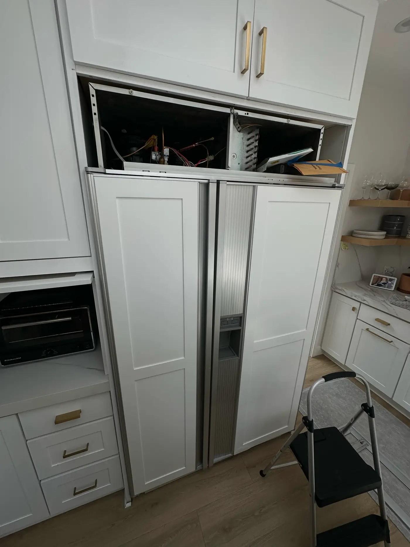 Panel-ready Sub-Zero built-in side-by-side refrigerator with white panels during a sealed-system repair
