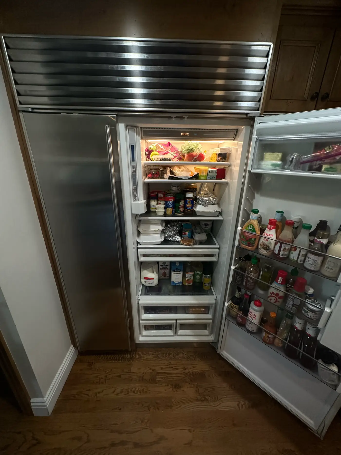 Sub-Zero built-in side-by-side refrigerator with the door open during a leak diagnosis