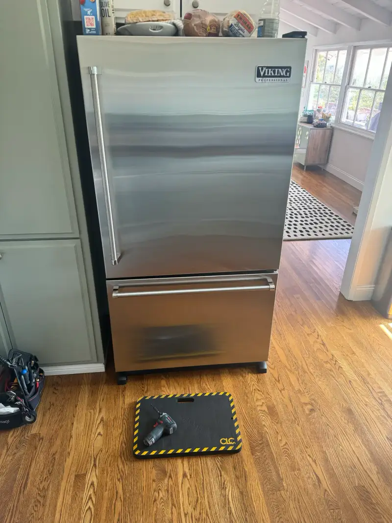 Viking Professional bottom-freezer refrigerator with the badge visible during an ice maker replacement