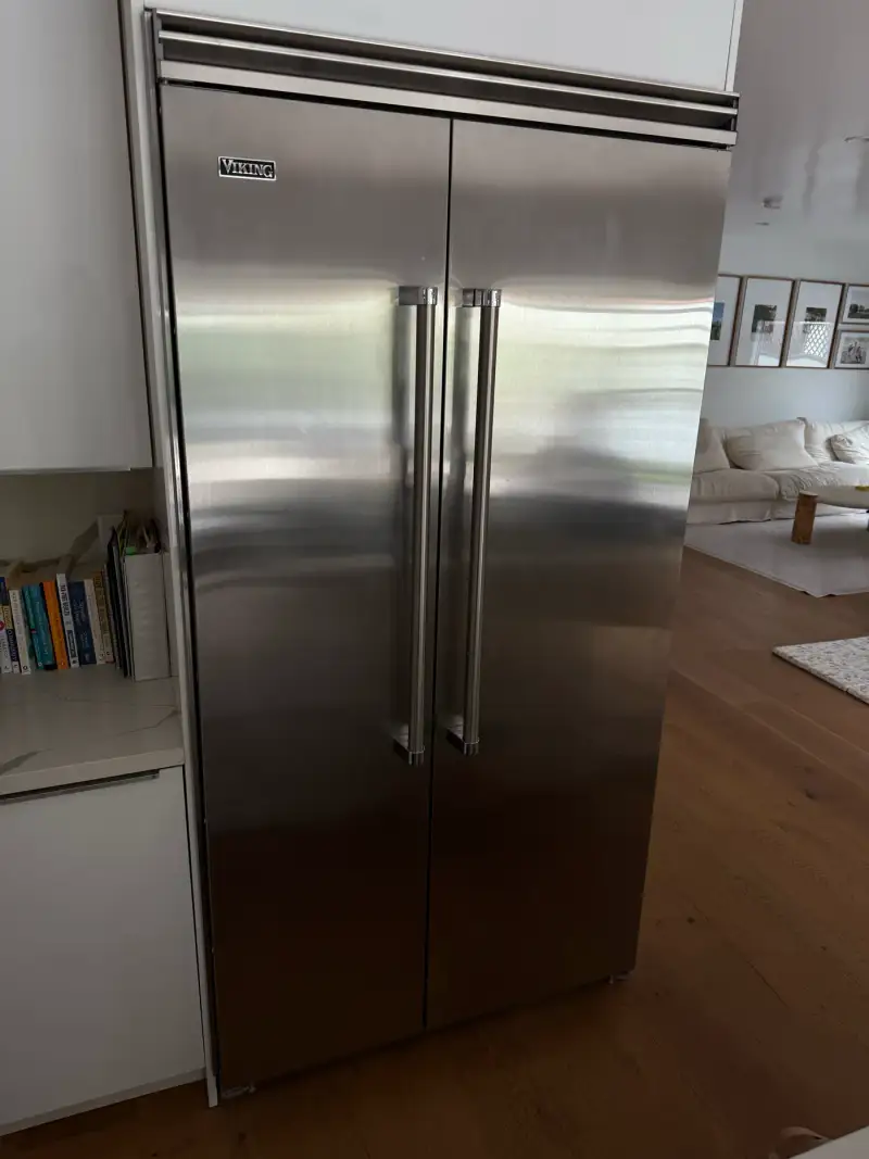 Viking built-in side-by-side stainless steel refrigerator in a bright modern open-plan kitchen