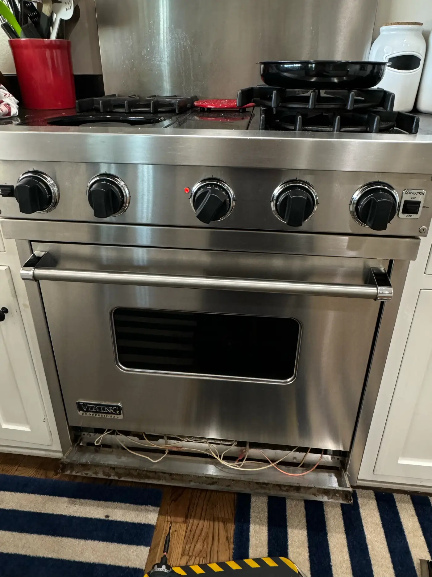 Viking range with the lower panel removed exposing ignition wiring during a diagnosis