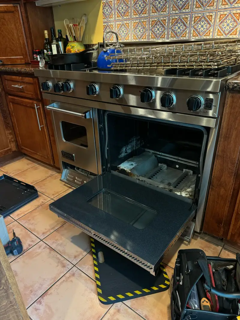 Viking 36-inch range with the oven door removed and laid flat during an igniter replacement