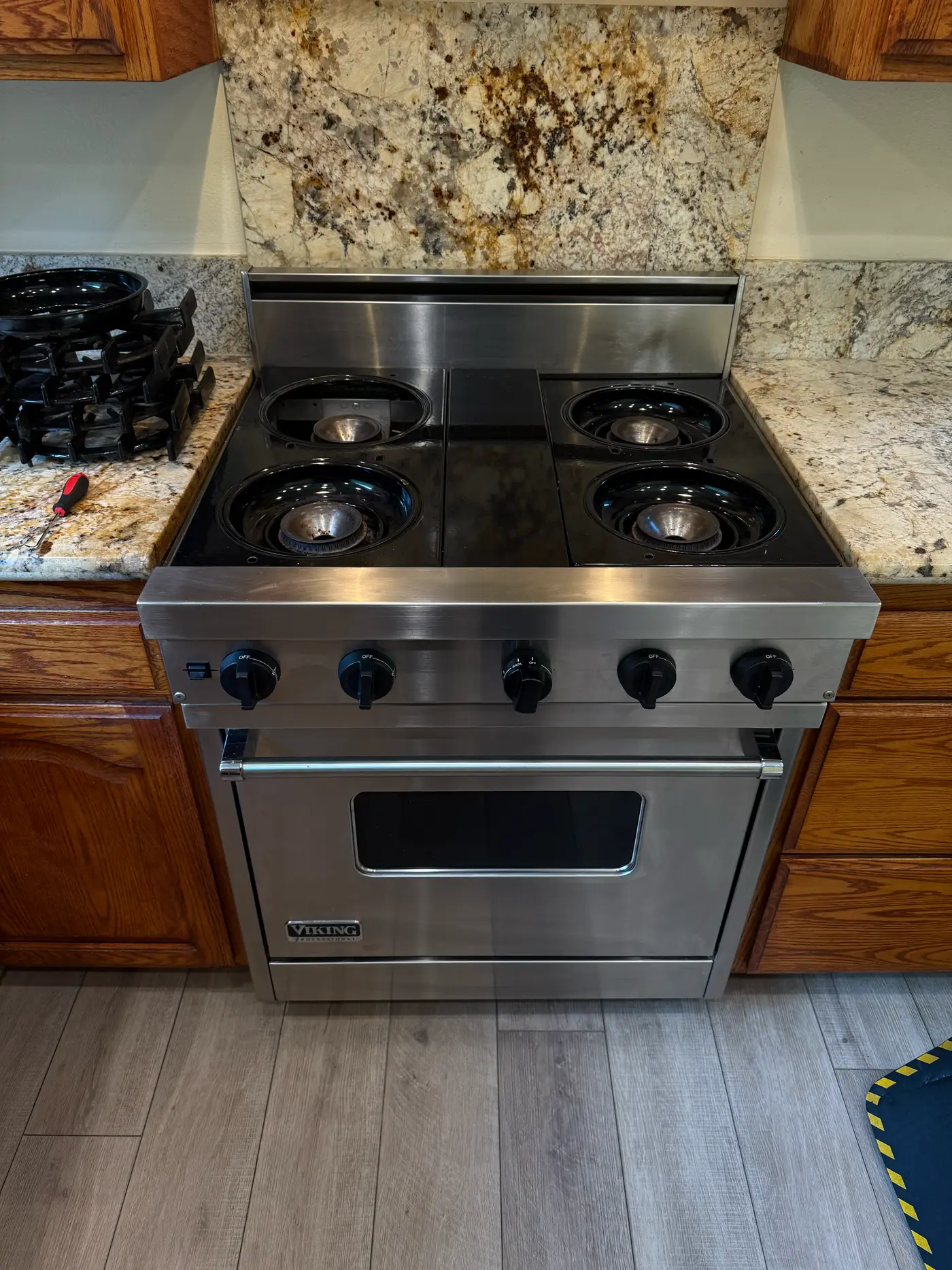Viking 30-inch stainless range with burner grates and caps removed during a spark electrode replacement