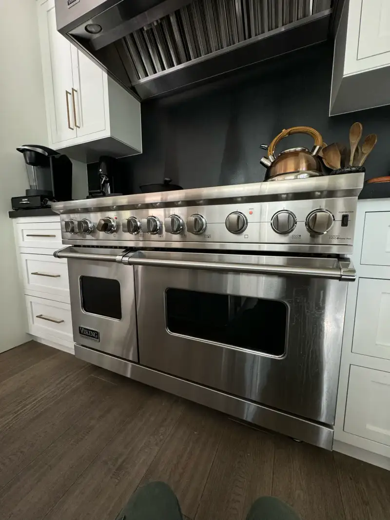 Viking Professional 48-inch double-oven range under a stainless hood in a modern white kitchen