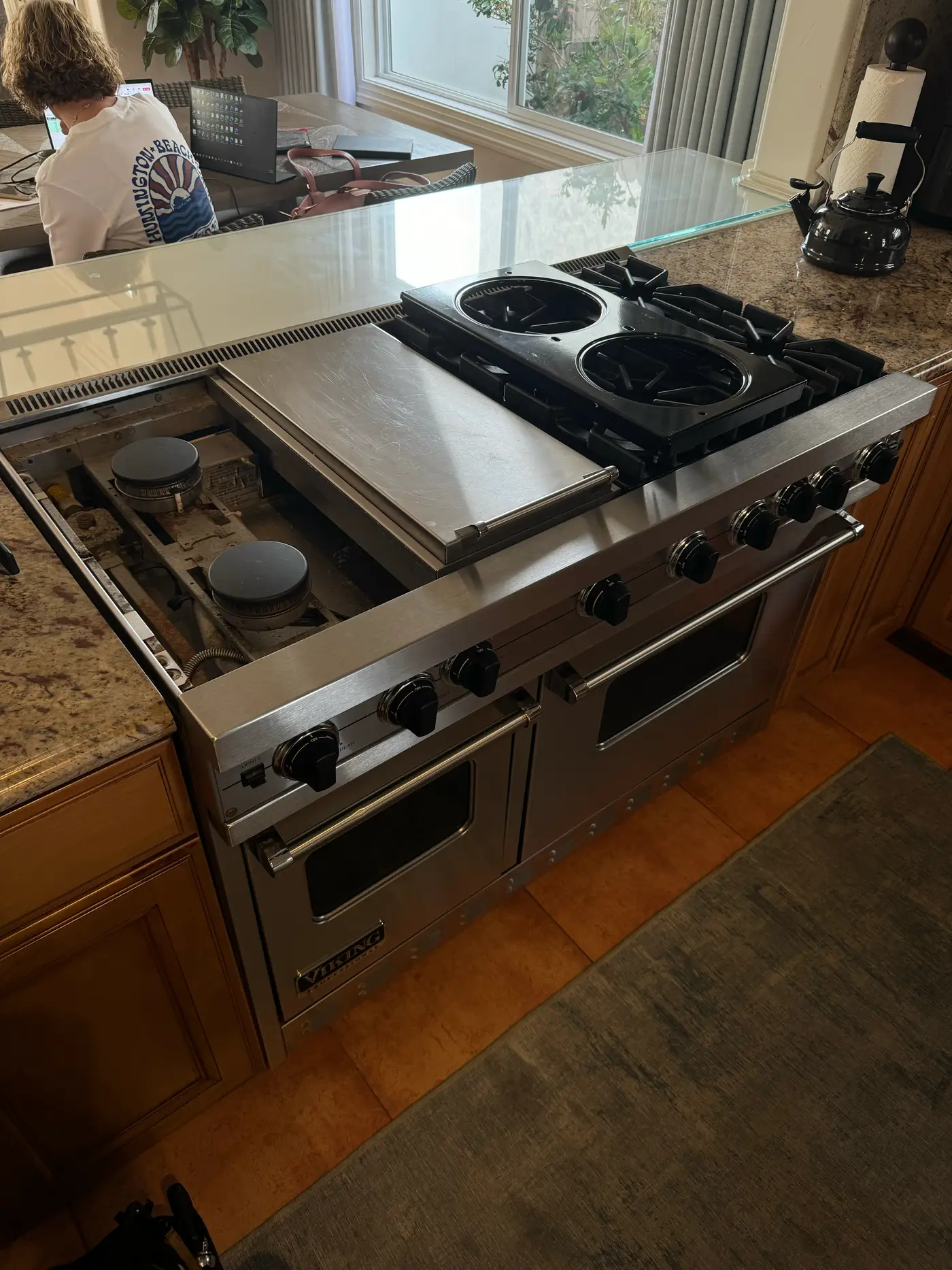Viking 48-inch island range with cooktop grates and burner assembly disassembled during an igniter replacement
