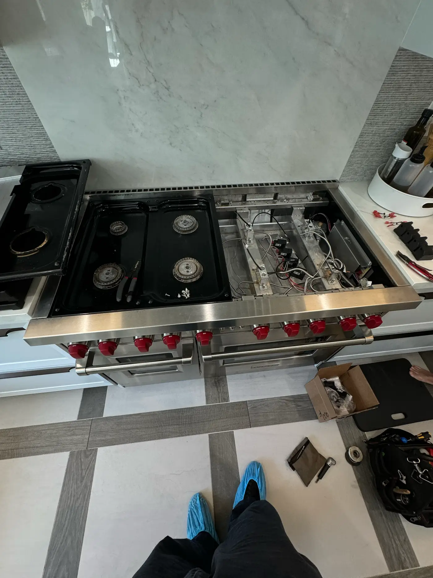 Wolf rangetop with the burner deck lifted and igniter modules and wiring exposed