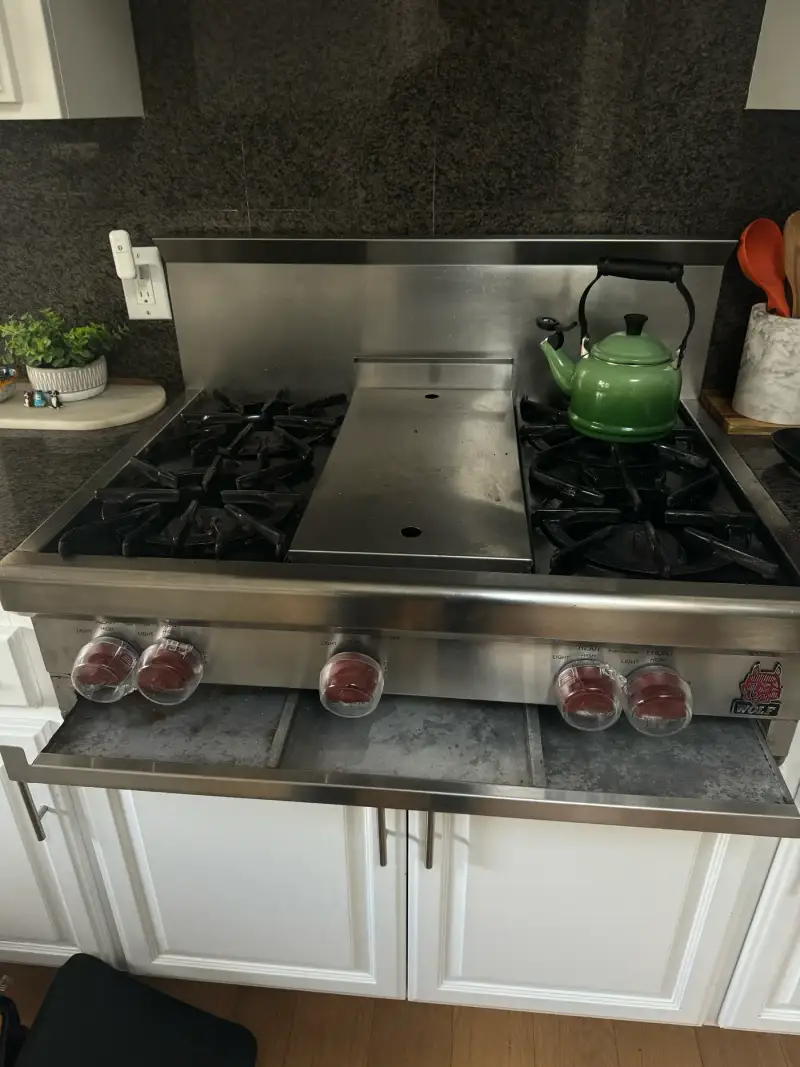 Wolf gas rangetop with griddle and newly installed red knobs after a spark switch replacement